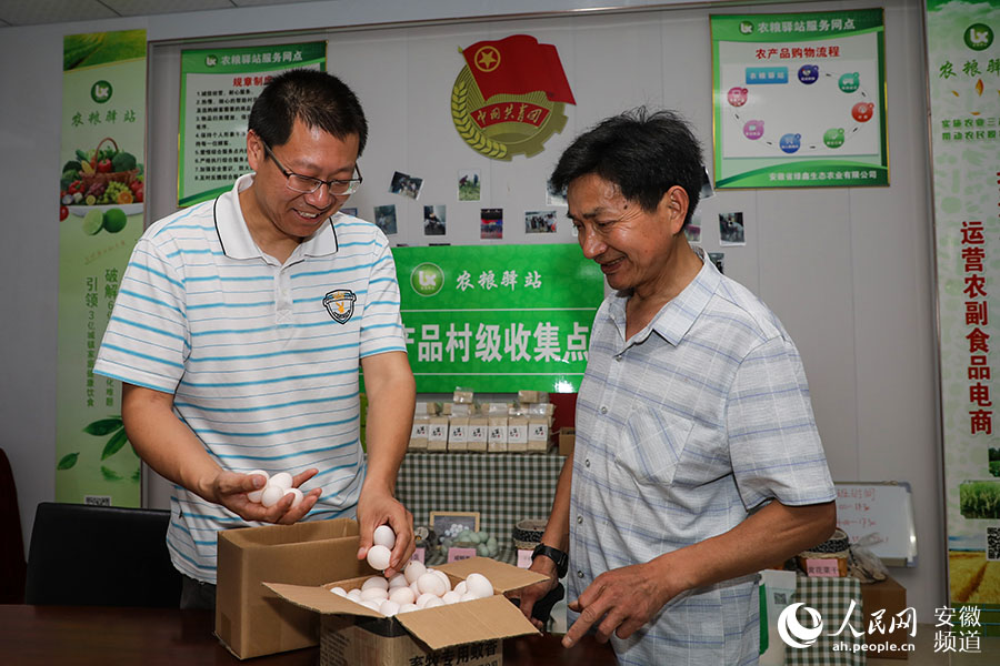 固镇县陡沟村贫困户（右）把收获的鸽子蛋送到农粮驿站，通过电商销售出去。张俊 摄